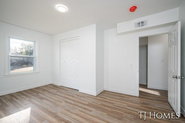 unfurnished bedroom with a closet and hardwood / wood-style flooring