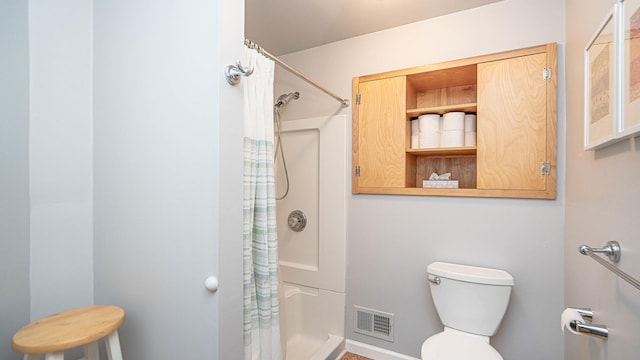 bathroom with a shower with shower curtain and toilet