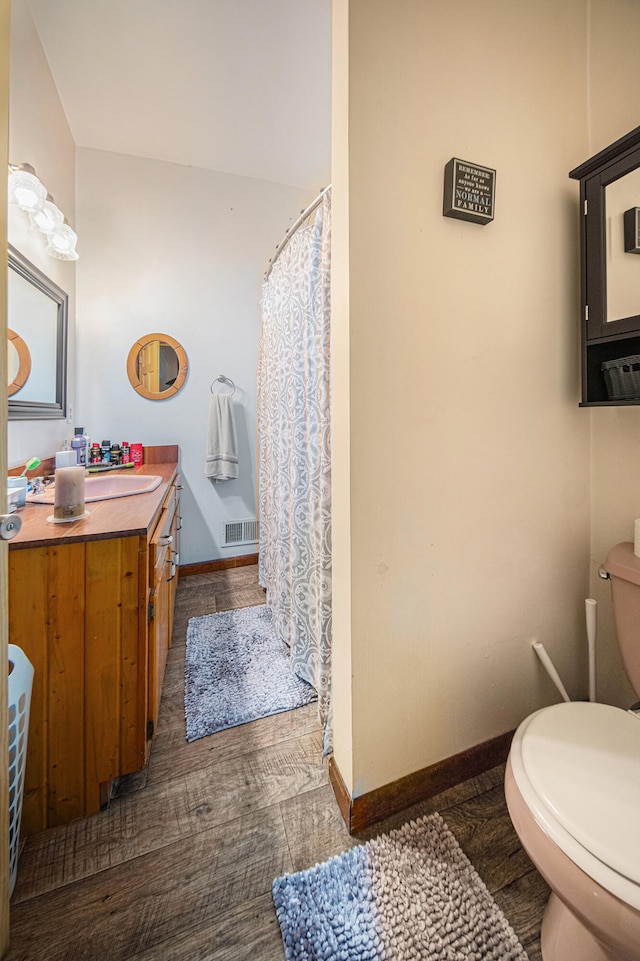 bathroom featuring toilet, hardwood / wood-style floors, and vanity