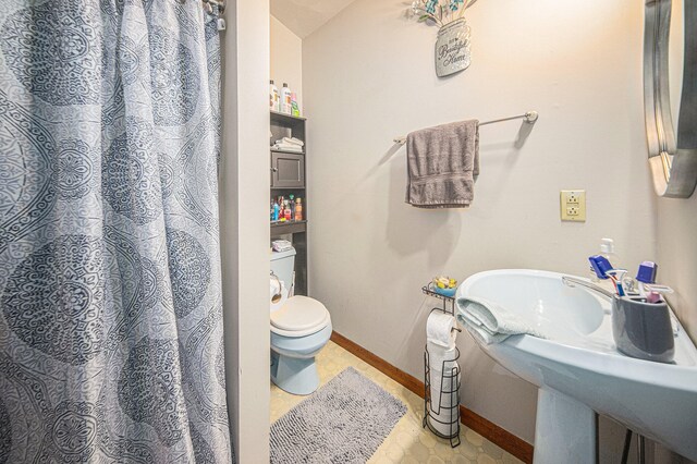 bathroom featuring toilet, tile patterned floors, and sink