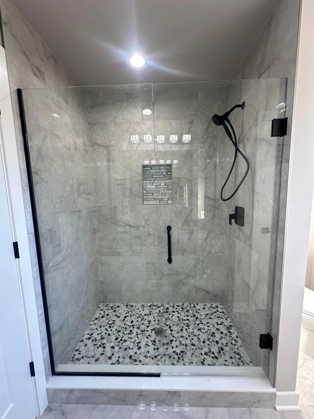 bathroom with toilet and a shower with door