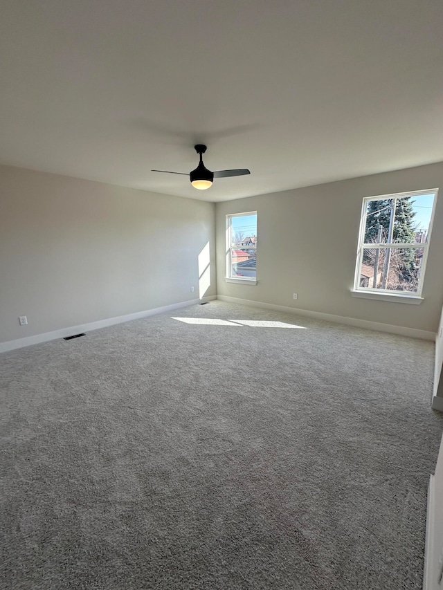 unfurnished room with ceiling fan, a healthy amount of sunlight, and carpet floors