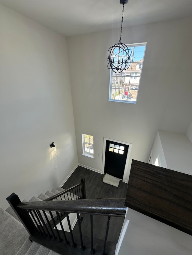 staircase with carpet, an inviting chandelier, and a healthy amount of sunlight