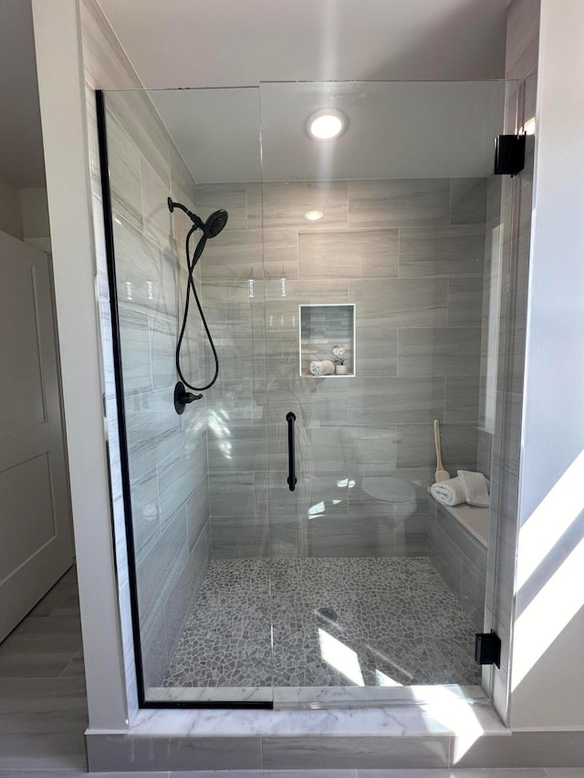 bathroom featuring a shower with shower door