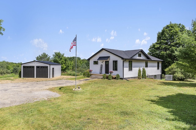 view of front of property featuring a front yard, an outdoor structure, and a garage