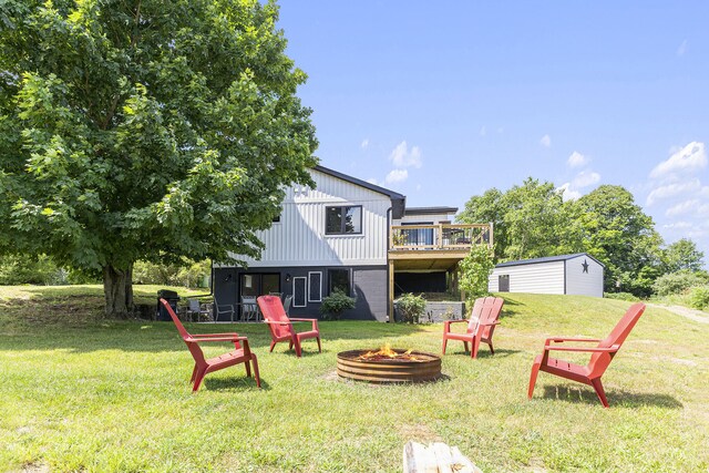 view of yard with a deck, an outdoor fire pit, and an outbuilding