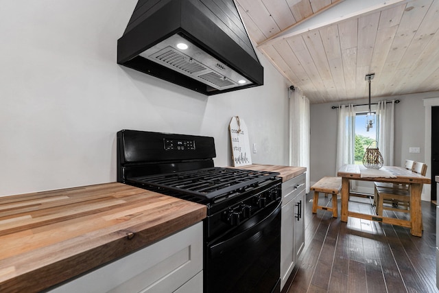 kitchen with custom exhaust hood, hanging light fixtures, wood counters, and black gas range