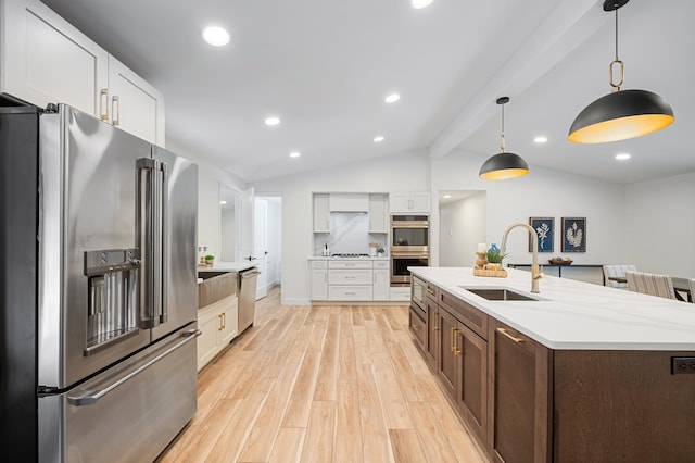 kitchen featuring vaulted ceiling with beams, sink, white cabinetry, appliances with stainless steel finishes, and light hardwood / wood-style floors