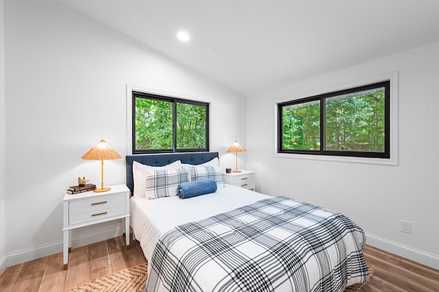 bedroom with wood-type flooring and lofted ceiling