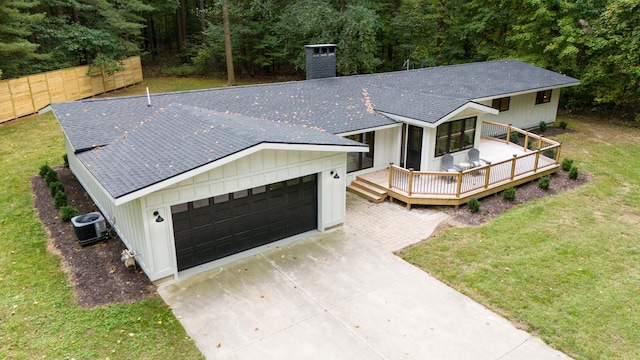 view of front of house with cooling unit, a front lawn, a deck, and a garage