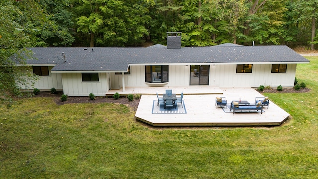 rear view of property with a lawn and a deck