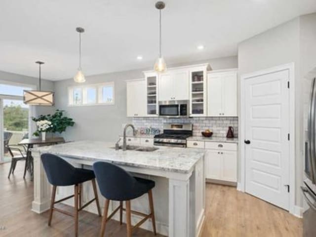 kitchen with appliances with stainless steel finishes, a healthy amount of sunlight, and white cabinetry