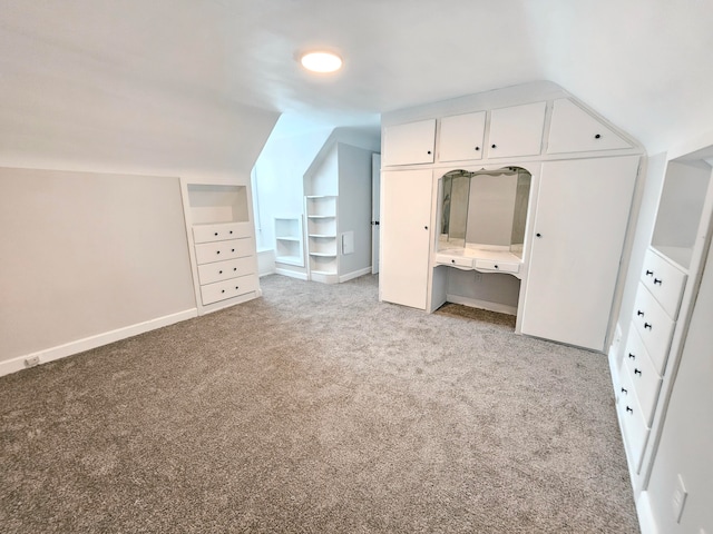 bonus room with lofted ceiling and light carpet