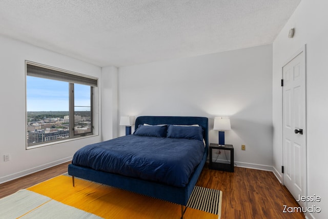 bedroom with a textured ceiling and dark wood-type flooring