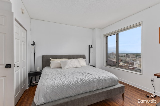 bedroom featuring a textured ceiling, a closet, and dark hardwood / wood-style flooring