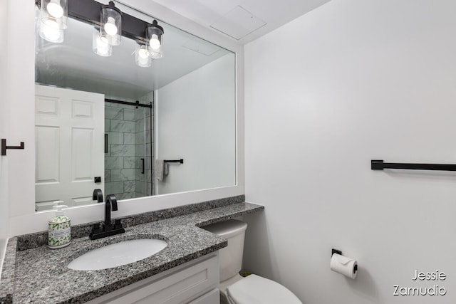 bathroom featuring vanity, toilet, and an enclosed shower