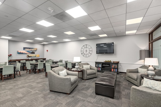 living room with a paneled ceiling and carpet