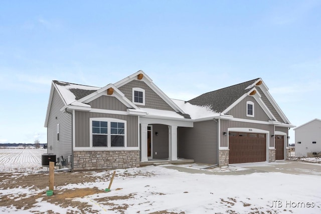 craftsman inspired home featuring board and batten siding, cooling unit, and stone siding