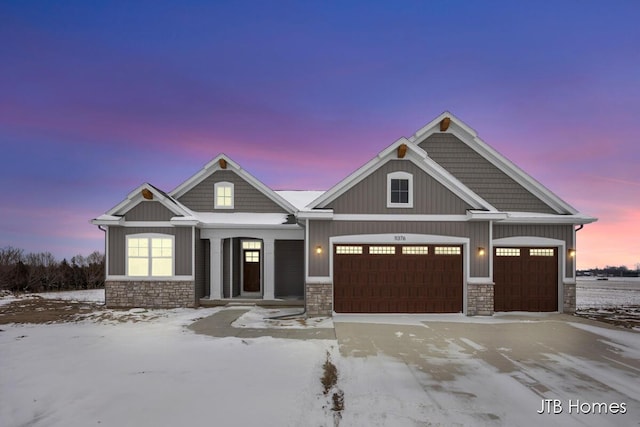 craftsman-style house featuring an attached garage, stone siding, board and batten siding, and concrete driveway