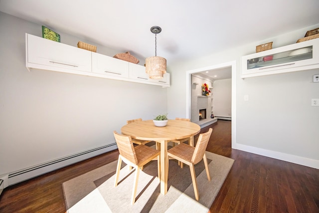 dining area featuring dark hardwood / wood-style flooring and a baseboard heating unit