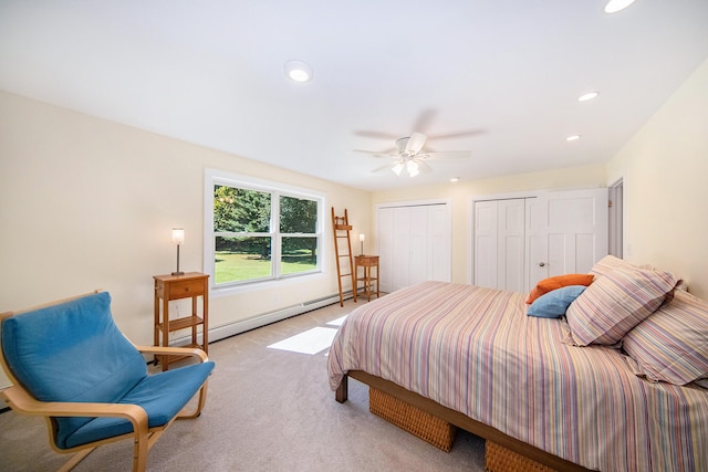 bedroom featuring ceiling fan, light colored carpet, multiple closets, and a baseboard radiator