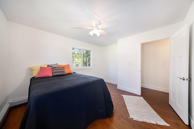 bedroom with dark hardwood / wood-style floors, ceiling fan, and a baseboard heating unit