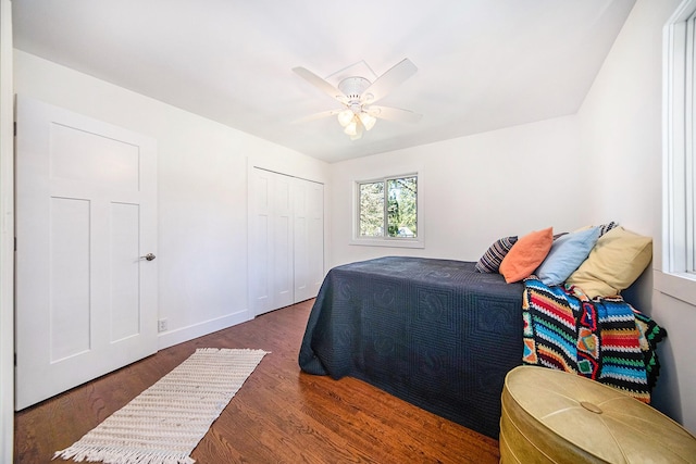 bedroom with ceiling fan, dark hardwood / wood-style flooring, and a closet