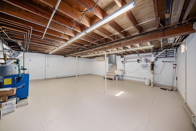 basement featuring sink and a baseboard radiator