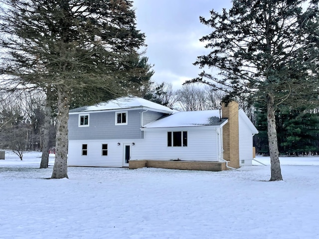 view of snow covered back of property