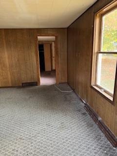 carpeted empty room with wooden walls