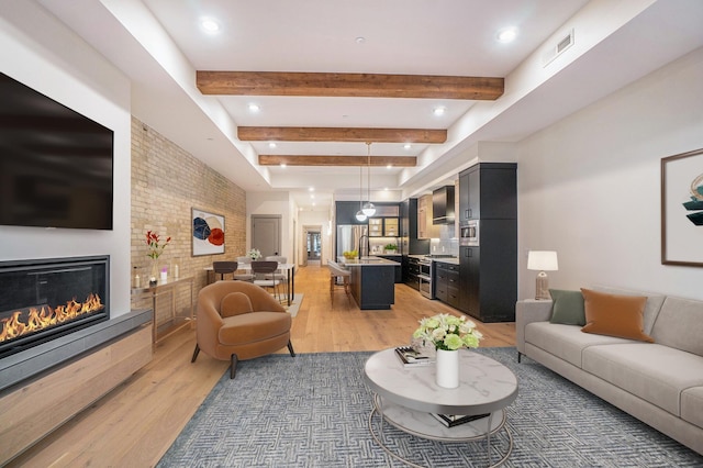 living room featuring beamed ceiling and wood-type flooring