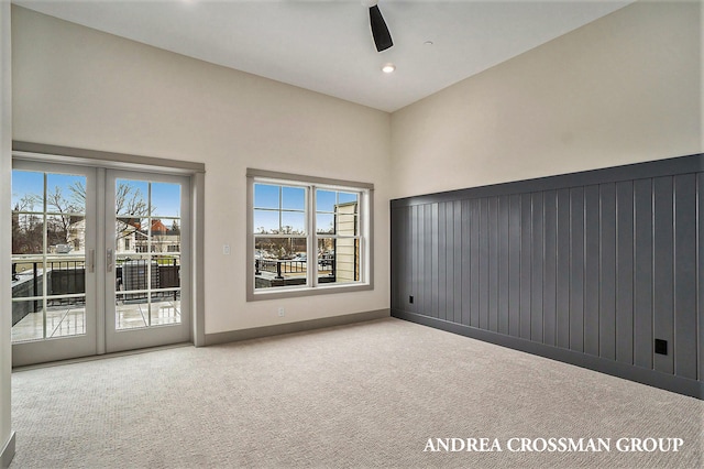 carpeted empty room featuring french doors, vaulted ceiling, and ceiling fan