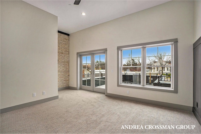 carpeted empty room featuring french doors and ceiling fan