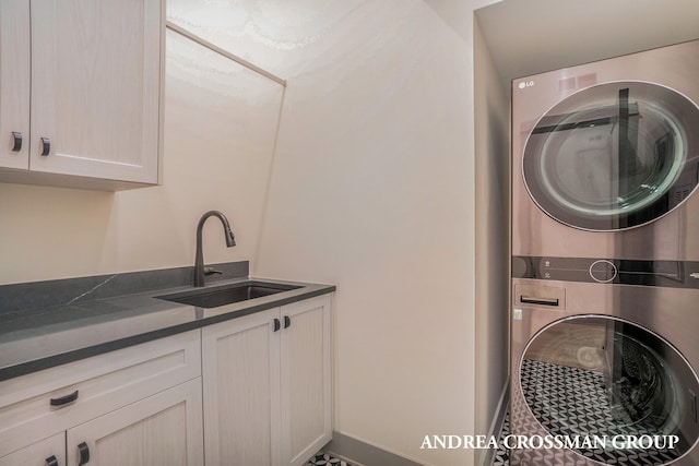 laundry room featuring sink, cabinets, and stacked washer and dryer