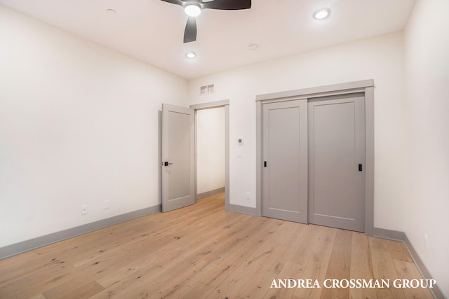 unfurnished bedroom with light hardwood / wood-style flooring, a closet, and ceiling fan