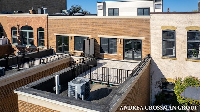 rear view of property with central AC unit and a balcony