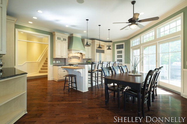 dining area with crown molding, ceiling fan, and dark hardwood / wood-style flooring