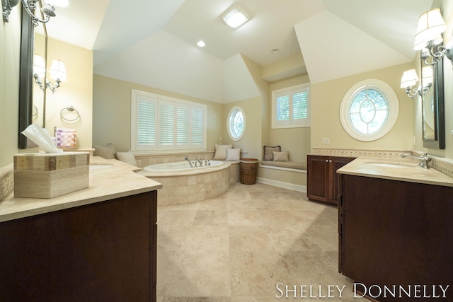 bathroom with tiled bath and vanity