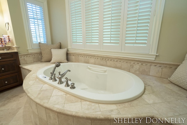 bathroom with a relaxing tiled tub and vanity