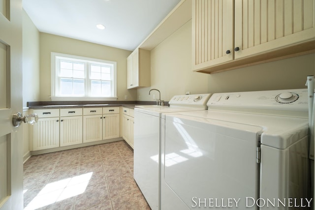 washroom featuring sink, cabinets, washing machine and dryer, and light tile patterned floors