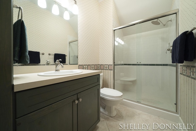 bathroom with a shower with door, toilet, tile patterned floors, and vanity