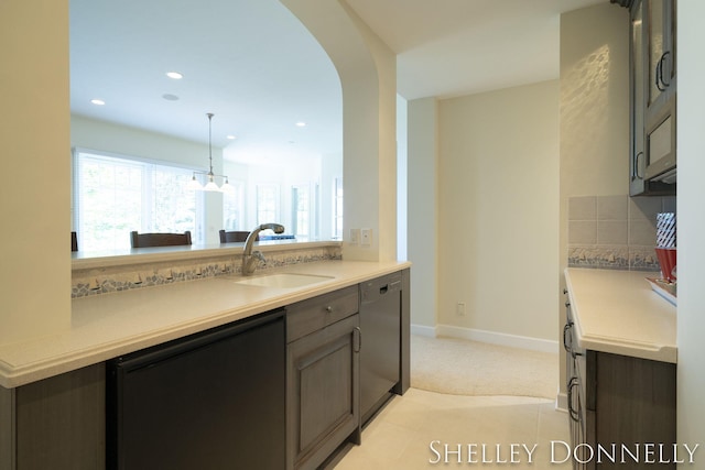 kitchen with sink, dark brown cabinets, backsplash, and dishwasher