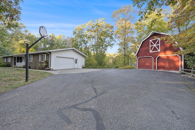 exterior space featuring an outdoor structure, a detached garage, a chimney, and a barn