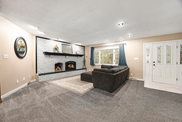 living room with visible vents, a brick fireplace, carpet flooring, a textured ceiling, and baseboards