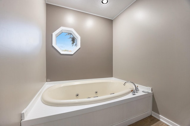 bathroom with a whirlpool tub, baseboards, and wood finished floors