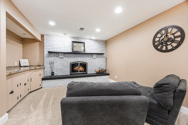 living room featuring a brick fireplace, recessed lighting, visible vents, and light colored carpet