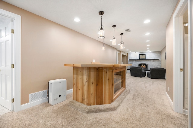 kitchen with recessed lighting, light colored carpet, a fireplace, and visible vents