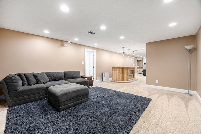 living area featuring light carpet, baseboards, visible vents, and a dry bar