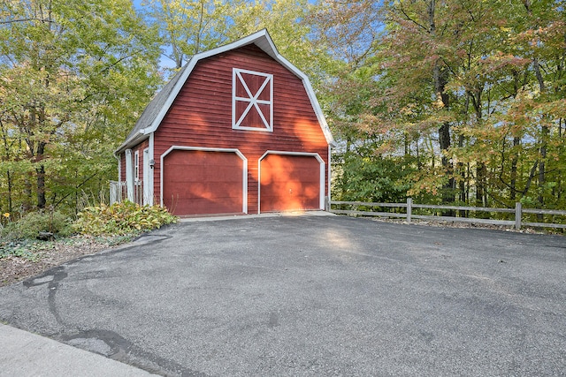 garage featuring a detached garage and fence