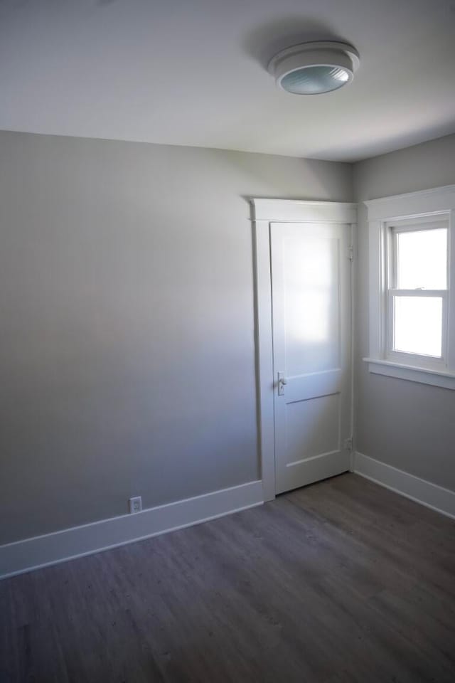 unfurnished room featuring dark wood-type flooring